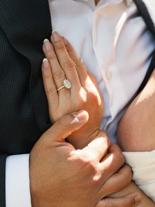 Close-up of a large oval diamond engagement ring on a bride's hand, inspiring luxury engagement photo ideas.