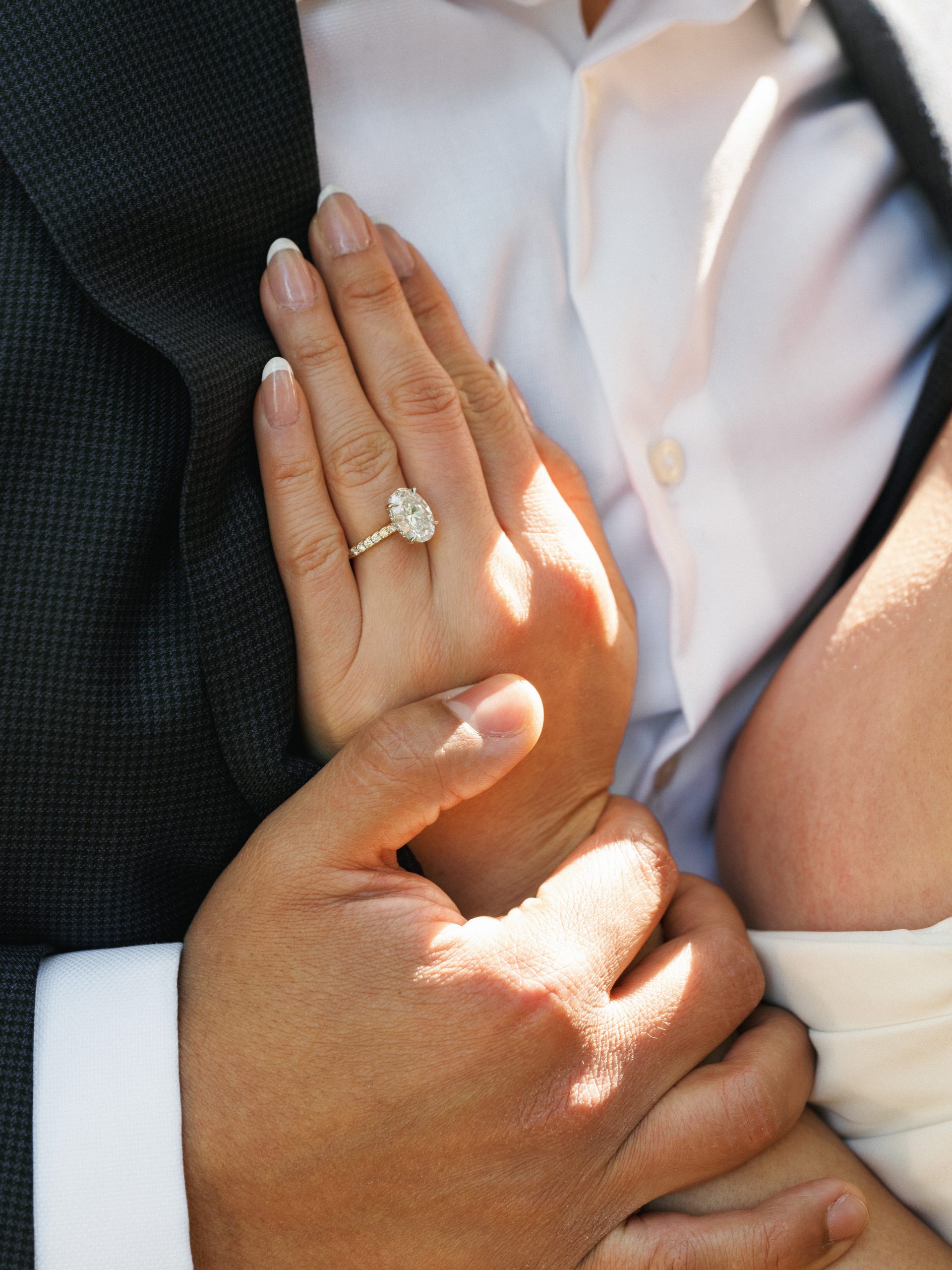 Close-up of a large oval diamond engagement ring on a bride's hand, inspiring luxury engagement photo ideas.