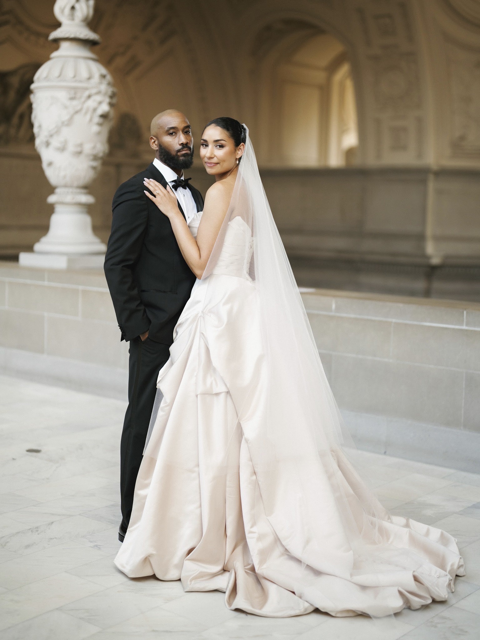 Couple standing together in a formal interior.