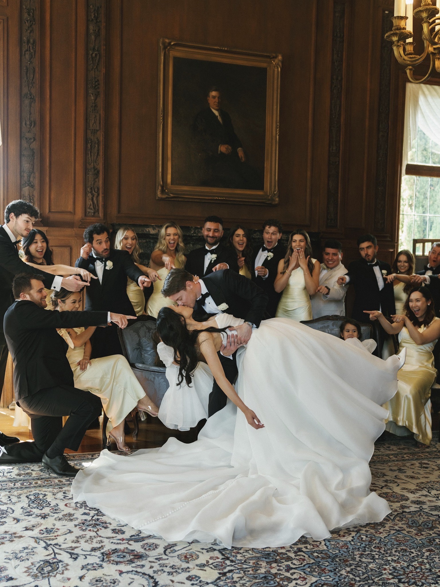 Wedding party celebrating around a couple indoors.