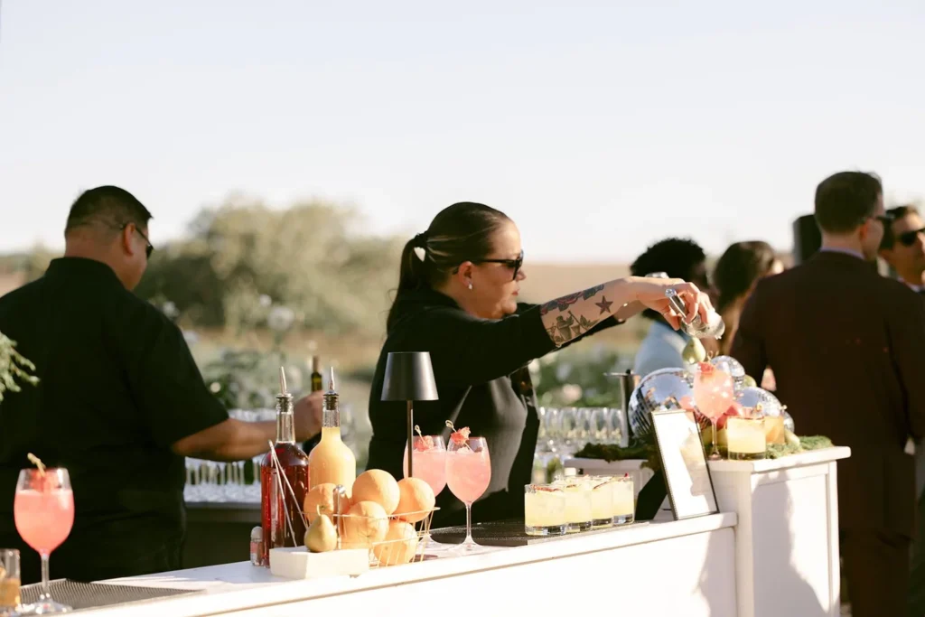 Woman bartender preparing cocktails at an outdoor bar