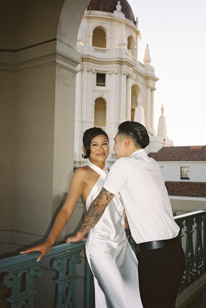 Candid wedding couple posing outdoor with beautiful architectural tower background