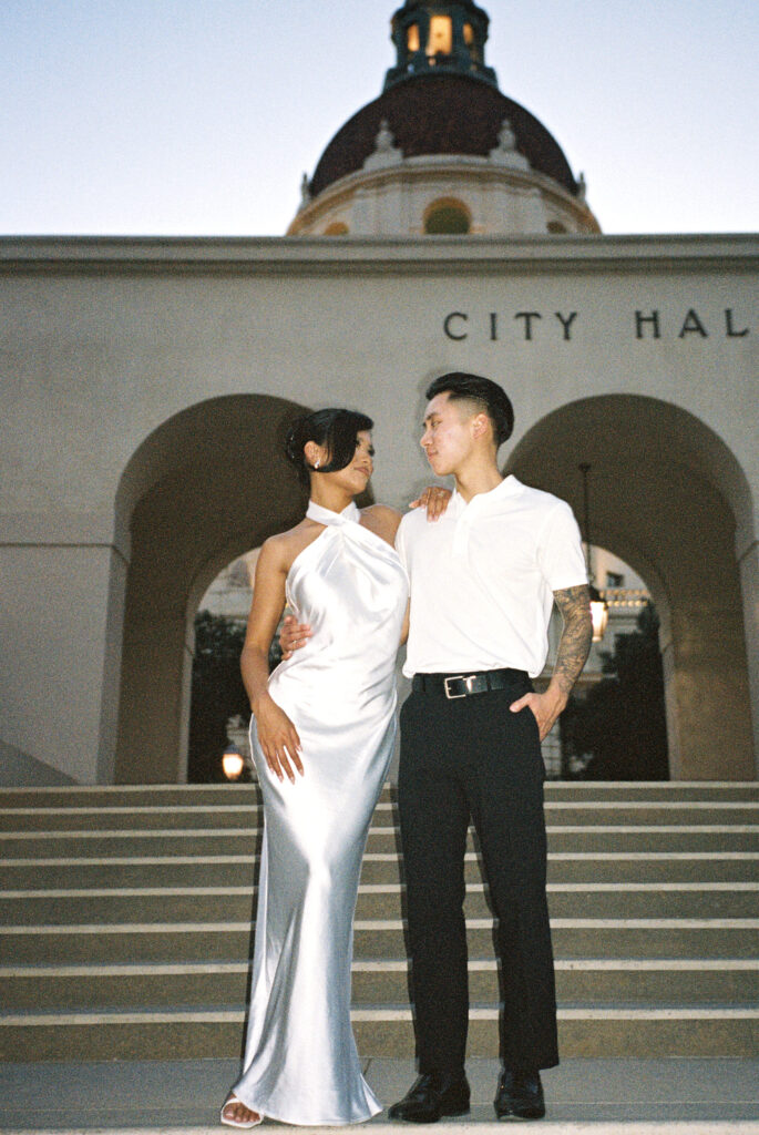 Newlyweds standing on stairs in front of luxury Pasadena City Hall building