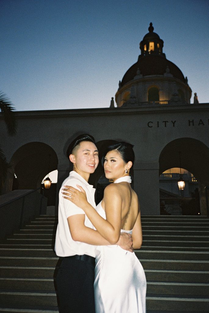 Elegant wedding couple embracing near historical building for blue hour wedding photos