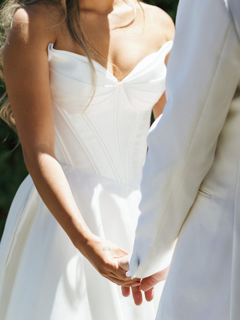 Close up of bride and groom holding hands during intimate outdoor wedding portrait session