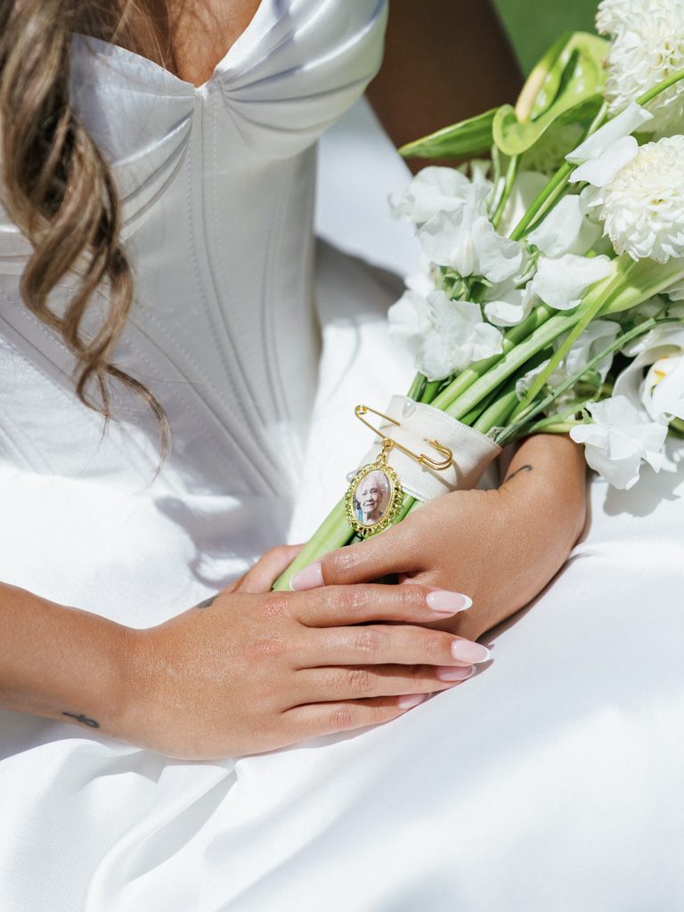 Detailed texture of luxury bridal bouquet stems with gold pin heirloom grandmother memorial charm decoration