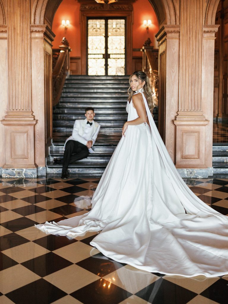 Editorial wedding portrait inside greystone mansion featuring dramatic architecture and high end couple styling