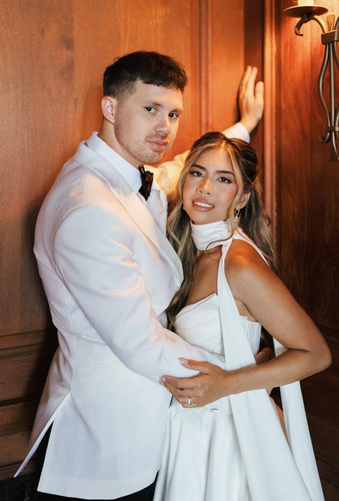 Editorial wedding couple portrait featuring chic white dinner jacket and modern strapless dress with neck scarf