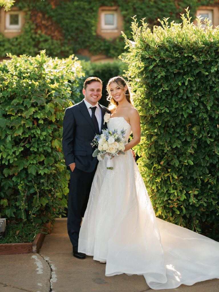 Full length portrait of newlyweds posing together outdoor at luxury California winery venue