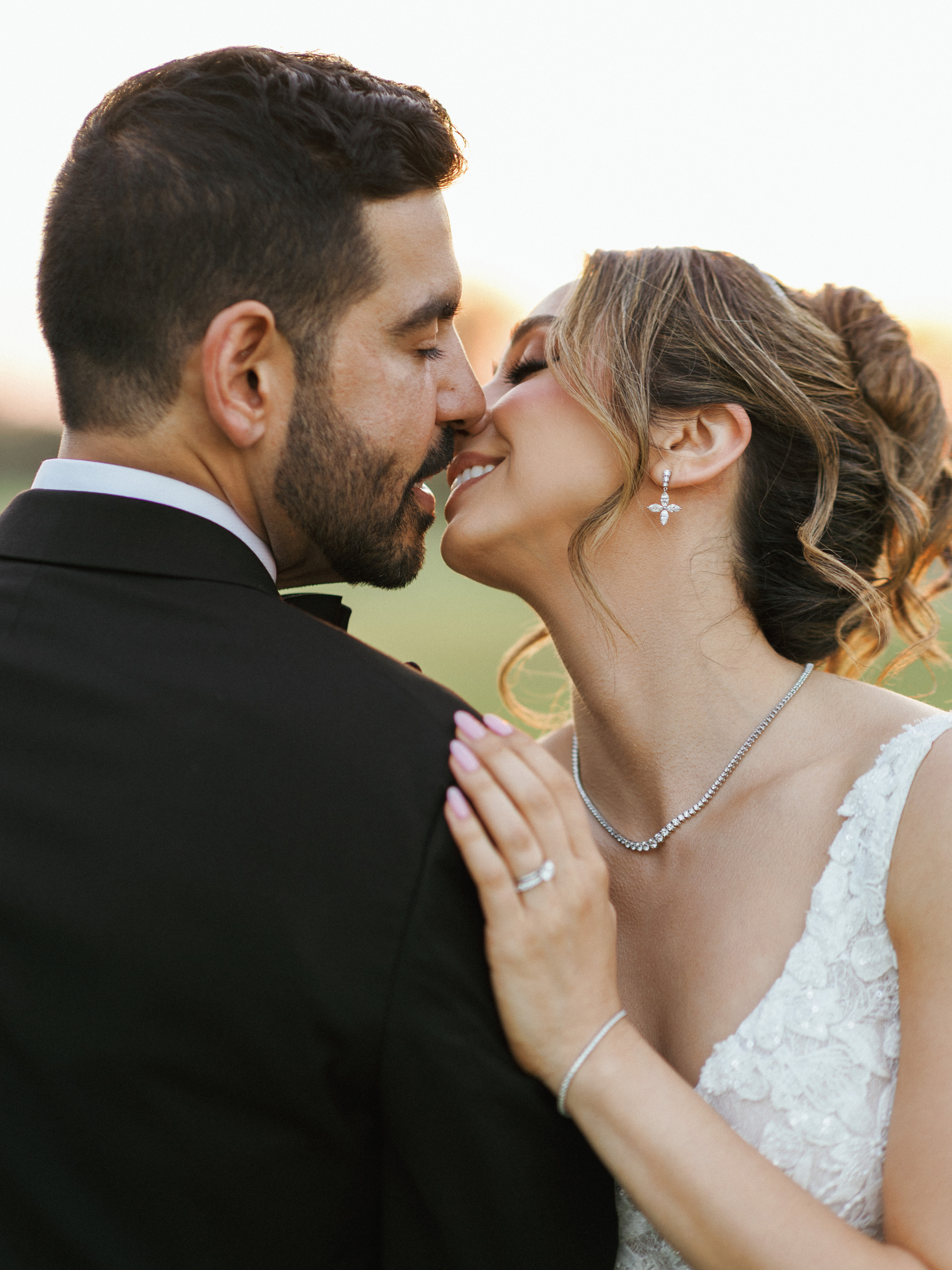 Romantic bride and groom sharing a tender kiss during outdoor wedding portrait session