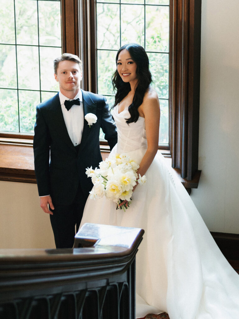 Classic black tie couple wedding portrait inside luxury mansion room with wood panels