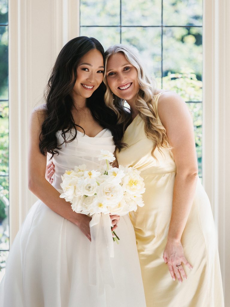Close up bridal party portrait featuring stunning brunette bride holding white peony bouquet