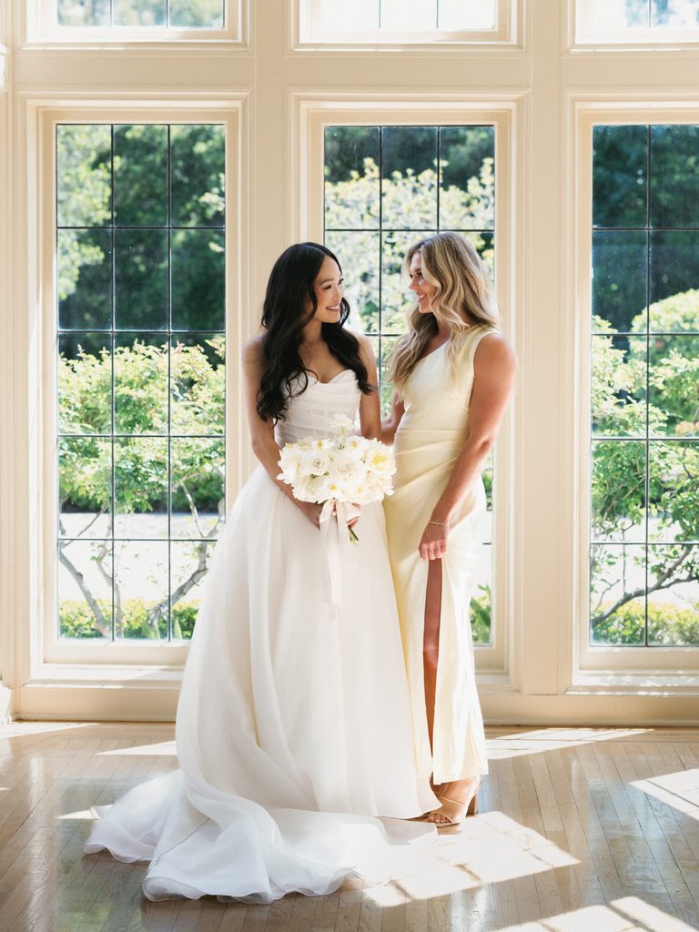 Sunlit indoor bridal photo featuring modern strapless wedding dress on hardwood floors