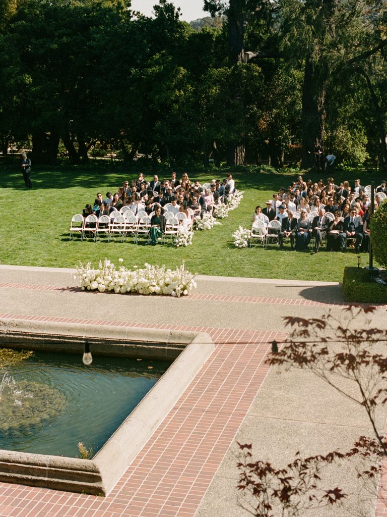 Elevated perspective of elegant wedding ceremony with white floral arrangements on grass