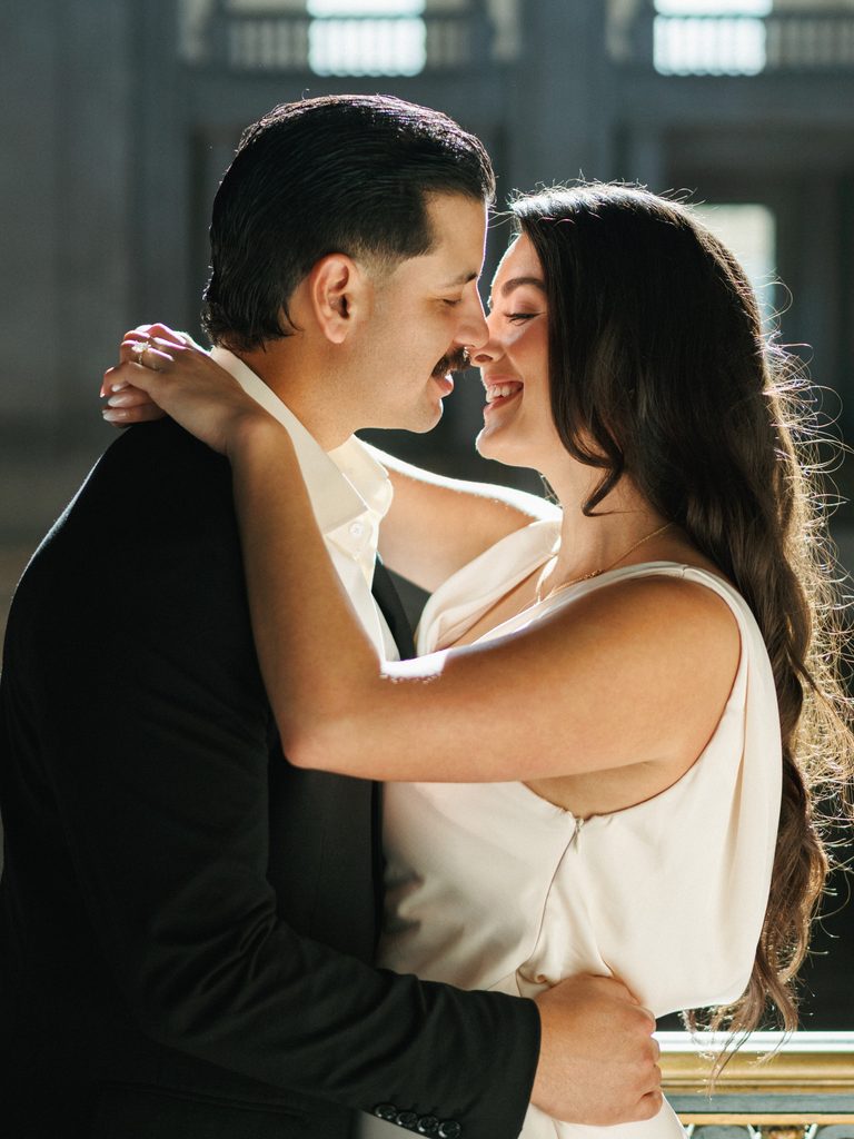 Romantic newlyweds hugging with bright sunlight background during California winter wedding photoshoot