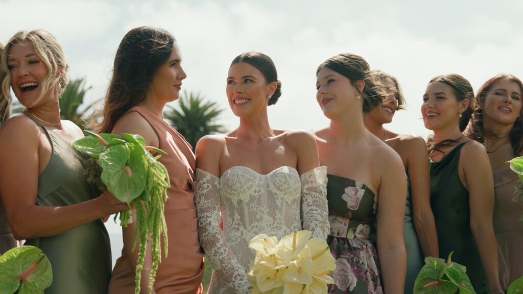 A bride and her bridesmaids holding bouquets with green anthuriums and yellow flowers. Photo by Dreamwood.