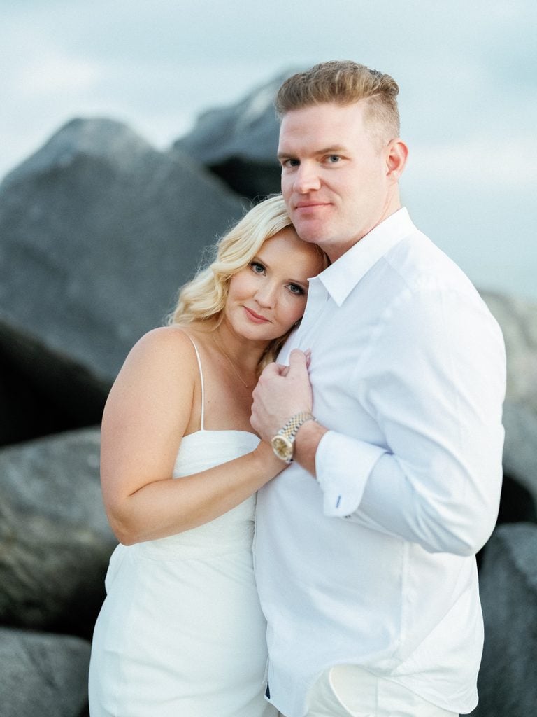 Candid wedding couple posing by the ocean for blue hour wedding photos