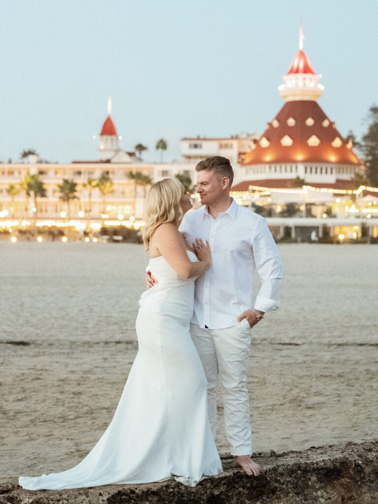 Bride and groom walking near ocean for romantic coastal blue hour wedding photos